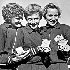 white and black picture of three ladies holding trophies