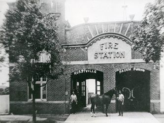 black and white picture of the Fire station in 1915, with a horse in front of the brink building